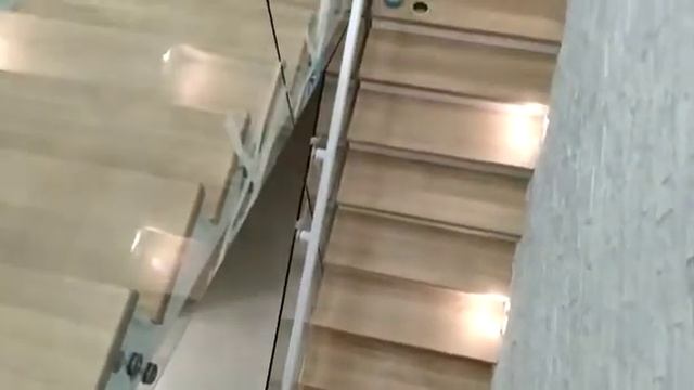 Облицовка лестницы деревом и перила из стекла
