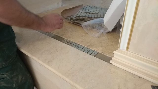 Укладка мозаики в мраморный пол.