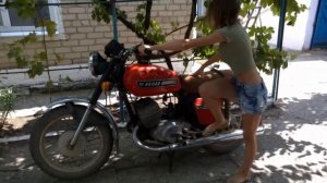 Красивая девушка заводит советский мотоцикл