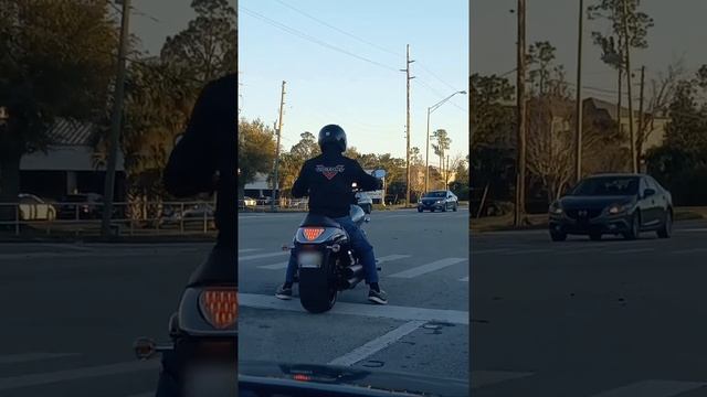 Man ready to jet off on his upside down pizza symbol motorbike