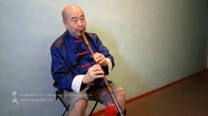 Му Юйчунь играет на бамбуковой флейте сяо китайскую мелодию