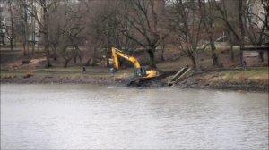 Экскаватор JCB работает на берегу озера Нижнее город Черняховск