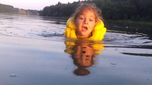 Девочка Поля плавает.  Child swimming in the river