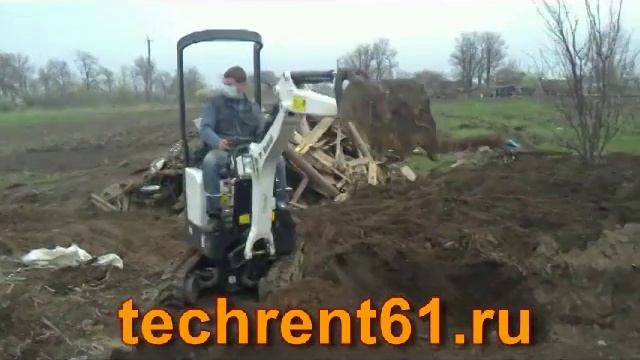 мини экскаватор копает котлован с погрузкой в кузов минитрактора