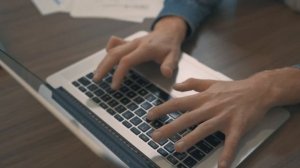Мужские руки печатают на клавиатуре ноутбука - работа на макбуке
