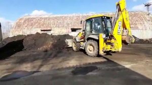 Загрузка грунта экскаватором-погрузчиком JCB в самосвал