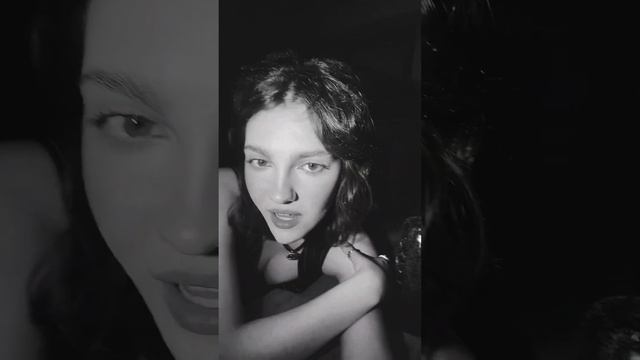 Emily Carey shows her cleavage in a black and white video.