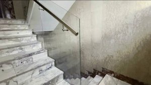 Стеклянные ограждения лестницы с поручнями из нержавейки. Прозрачные перила на мраморной лестнице.