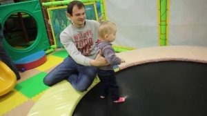 Маленькая девочка первый раз прыгает на батуте