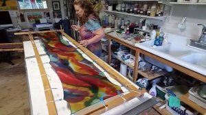 Hand painting a silk scarf.