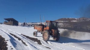 Трактор Т-16 буксует по в Снегу с Полный лафет Грузом