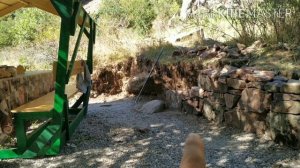 Подпорная стена из дикого камня возле беседки.