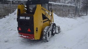 Минипогрузчик убирает снег