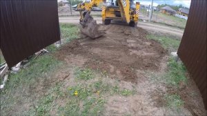 Трактор выравнивает заезд на участок