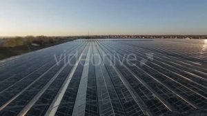 Large Industrial Building With a Glass Angled Roof Reflecting The Sun's Rays.