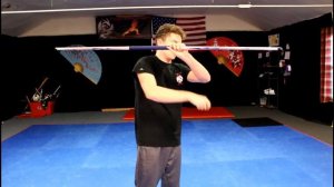 Трюк с перекрещиванием посоха Бо через плечо