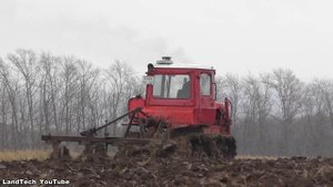 Гусеничные тракторы Агромаш 90ТГ, ДТ-75 и колесный Massey Ferguson 6713 пашут поле в деревне