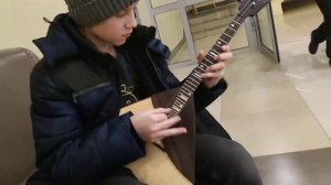 мальчик играет на балалайке Скерцо Баха.