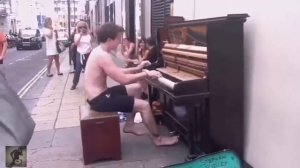 Парень играет на пианино на улице.