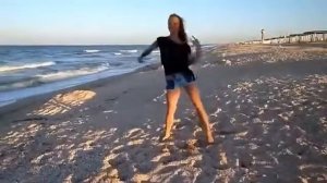 Девушка красиво танцует на море