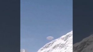 Туристам в горах Китая удалось запечатлеть медленно парящий дискообразный НЛО, улетающий за гору.