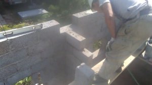 Баня из керамзитобетонных блоков с шиферной крышей и флюгером