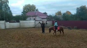 Кира катается на лошадке.