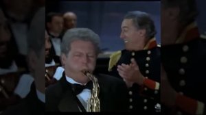 Билл Клинтон и его клон играют на саксофонах.