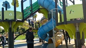 Девочки подружки в веревочном парке на детской площадке, играют и веселятся, катаются на горках