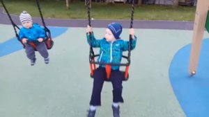 Елисей на детской площадке катается на качелях