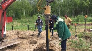 Монтаж винтовых свай при помощи буровой. Камни в земле.
