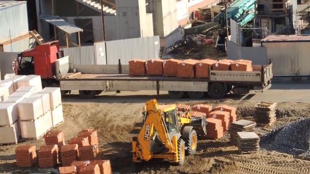 Выгрузка кирпича из Грузовика с бортовым полуприцепом