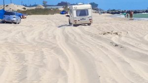 Нива на пляже по песку с кемпером