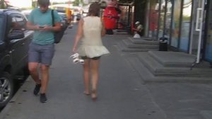 Босая девушка, идущая по городскому тротуару