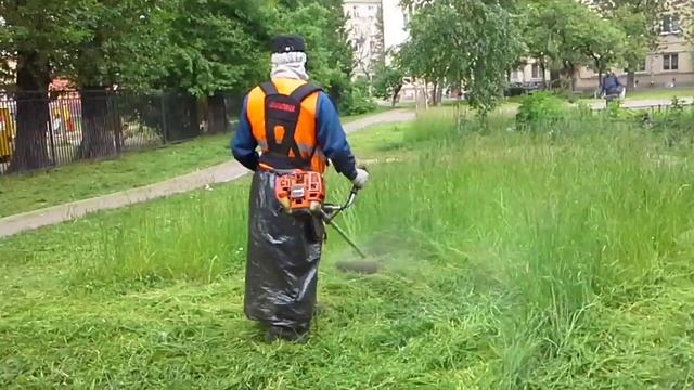 Косит траву газонокосилкой