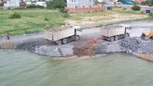 Continuing the process, a wheel loader is being used to push and move stones towards deeper waters!