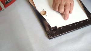 Обивка открывающейся крышки подлокотника кожзаменителем.