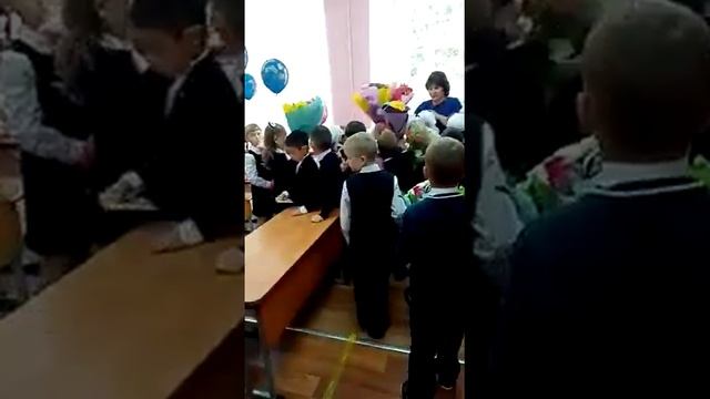 Первый раз - в первый класс! дарят цветы учителю
