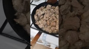 Тушеная свиная шея с луков со специями в казане.