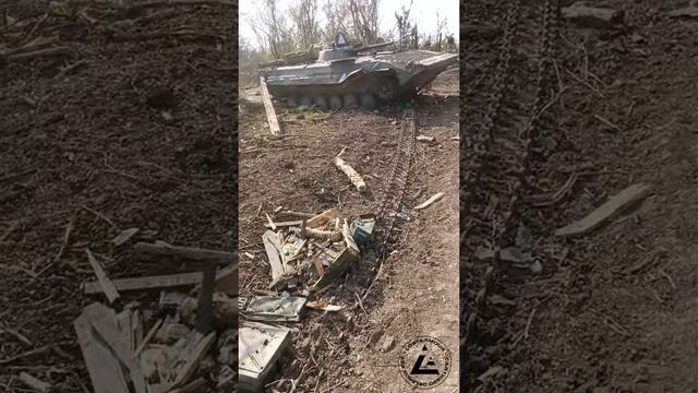 Боец ВСУ шагает вдоль одного из скоплений уничтоженной бронетехники ВСУ у н.п. Работино