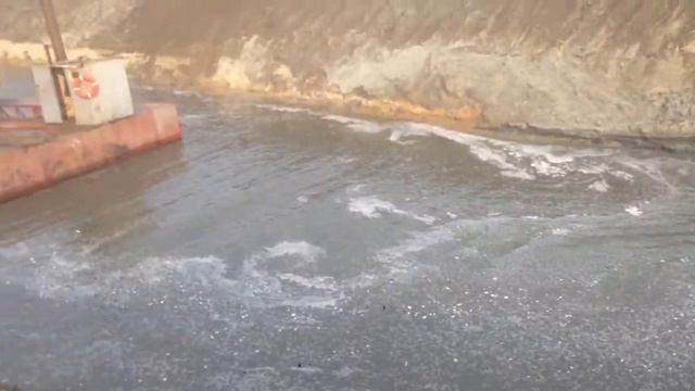 Экскаватор копает дно реки на понтоне