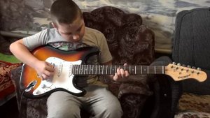Ребенок играет на электрогитаре