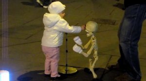 маленькая девочка танцует со скелетом