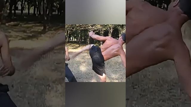 Coach and student: fall MMA-style sparring outside in the park