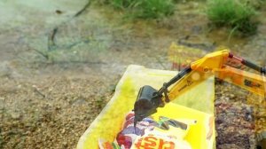 Экскаватор грузит пакетики в грузовик и карьерный самосвал