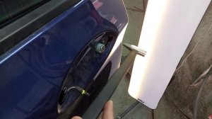Ремонт безокрасочным методом потянутой острой вмятины на алюминиевой двери BMW.