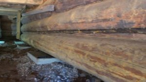 Замена гнилых бревен в деревенском доме.