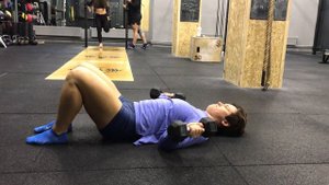 Вращение плеч внутрь лежа на полу с гантелями