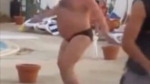 Мужик танцует на пляже с аниматором