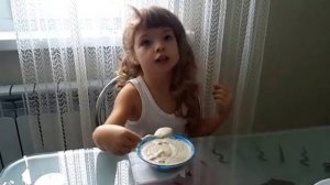 Девочка есть вкусную кашу с модной тарелки с Робокарами и от этого каша еще вкуснее